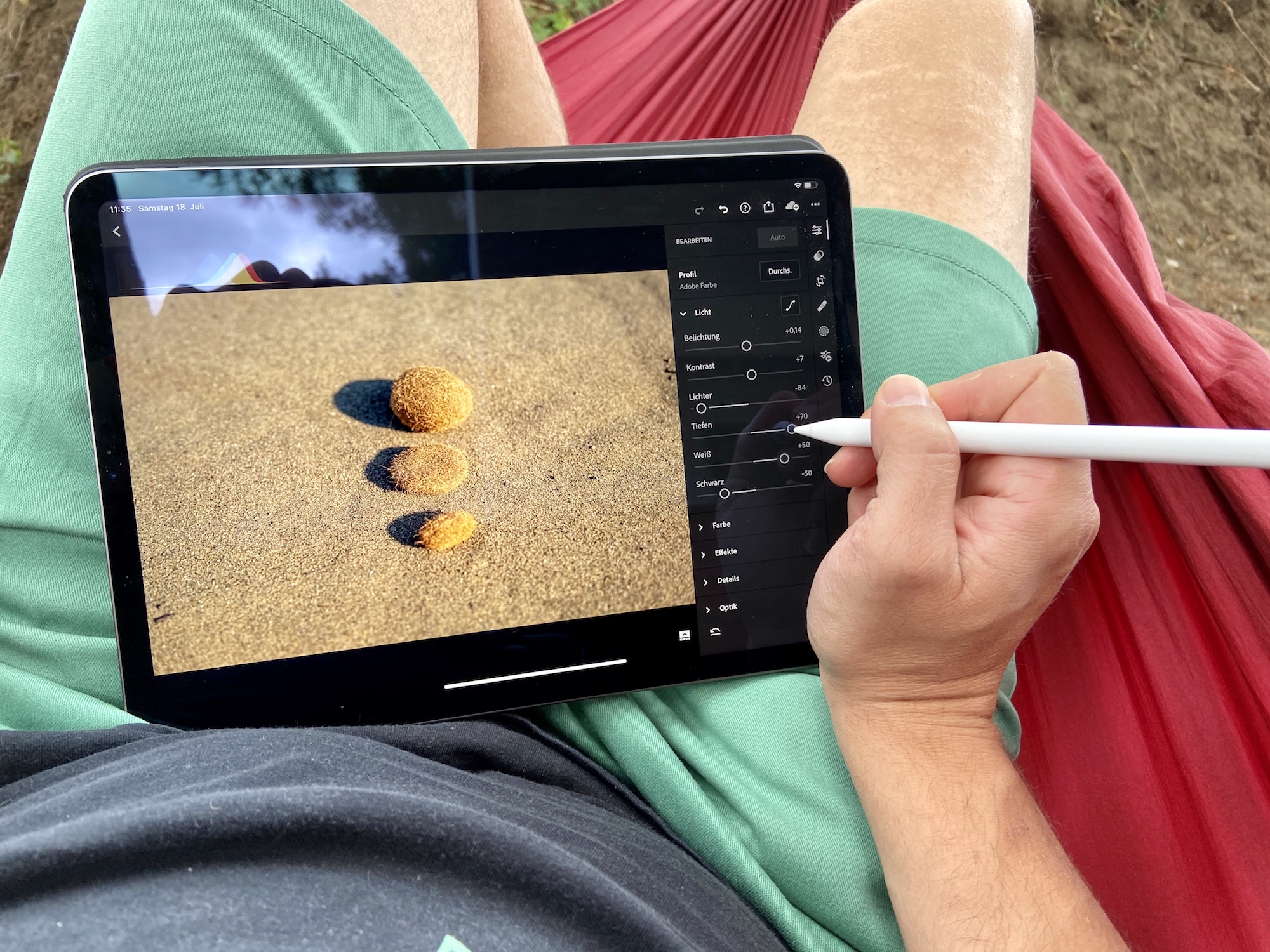 Editing photos on an iPad Pro with the Apple pencil in Lightroom while sitting in a hammock.